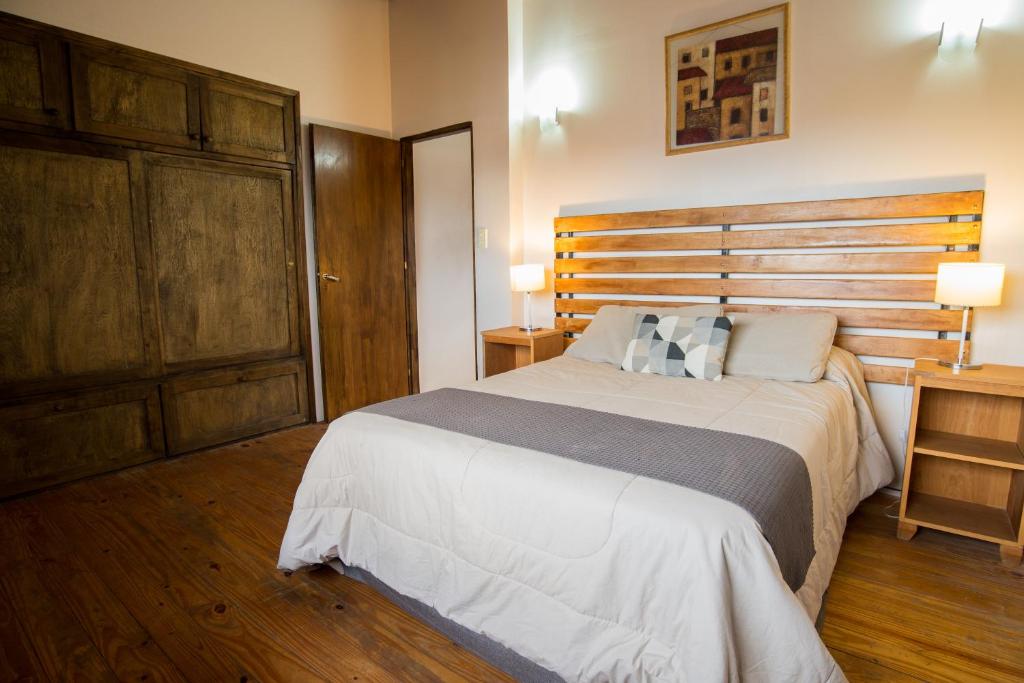 乌斯怀亚Magallanes Home的一间卧室配有一张大床和木制床头板