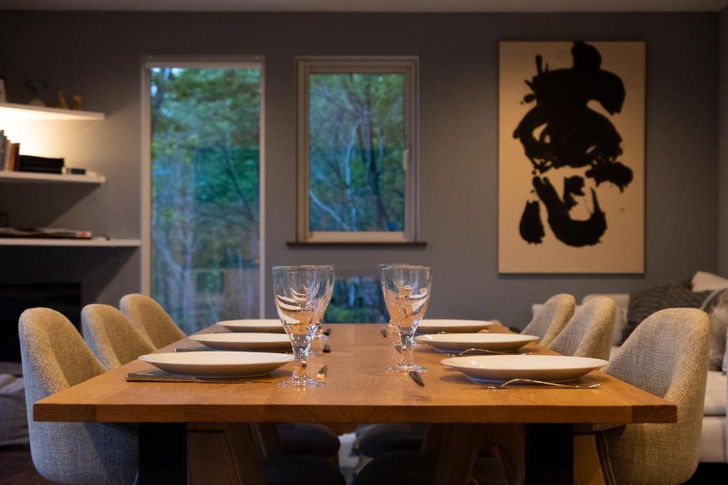 二世古森林度假屋的一间带木桌和椅子的用餐室