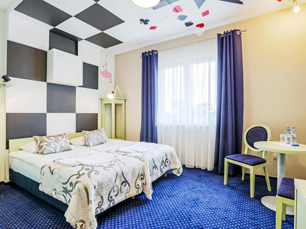 RaszowaHotel Magiczny Zakątek的一间卧室配有一张床和一个 ⁇ 板墙