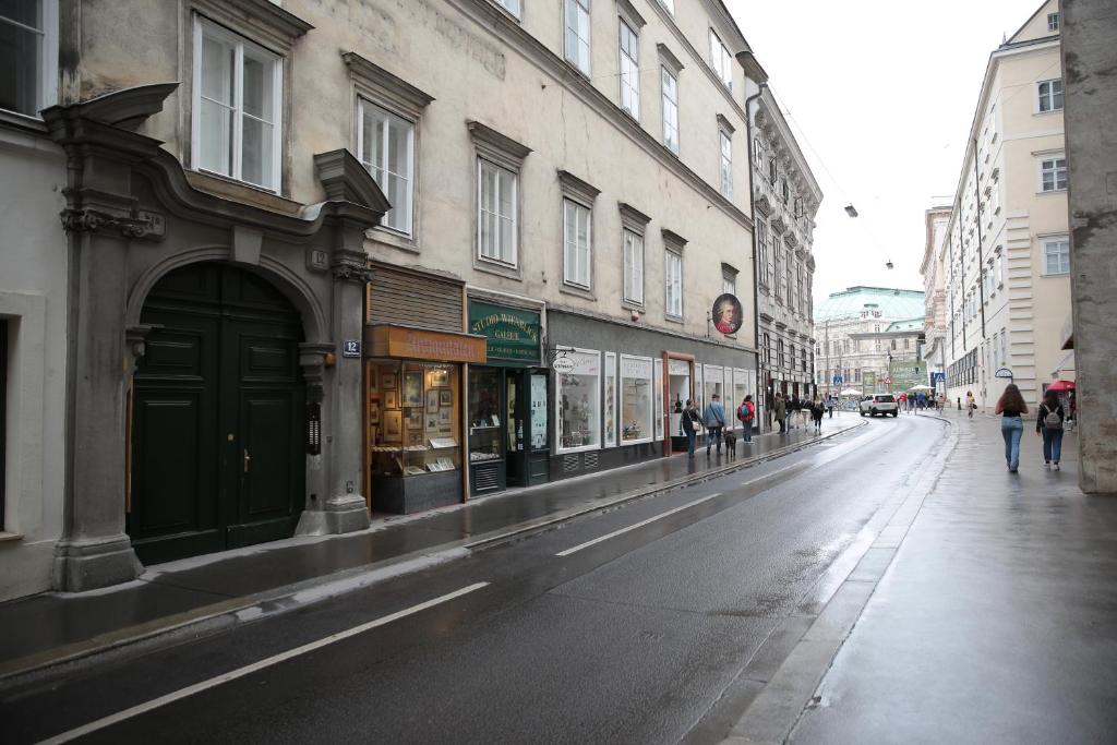 维也纳Heart of Vienna - City Apartment的一条空荡荡荡的城市街道,人们在人行道上走