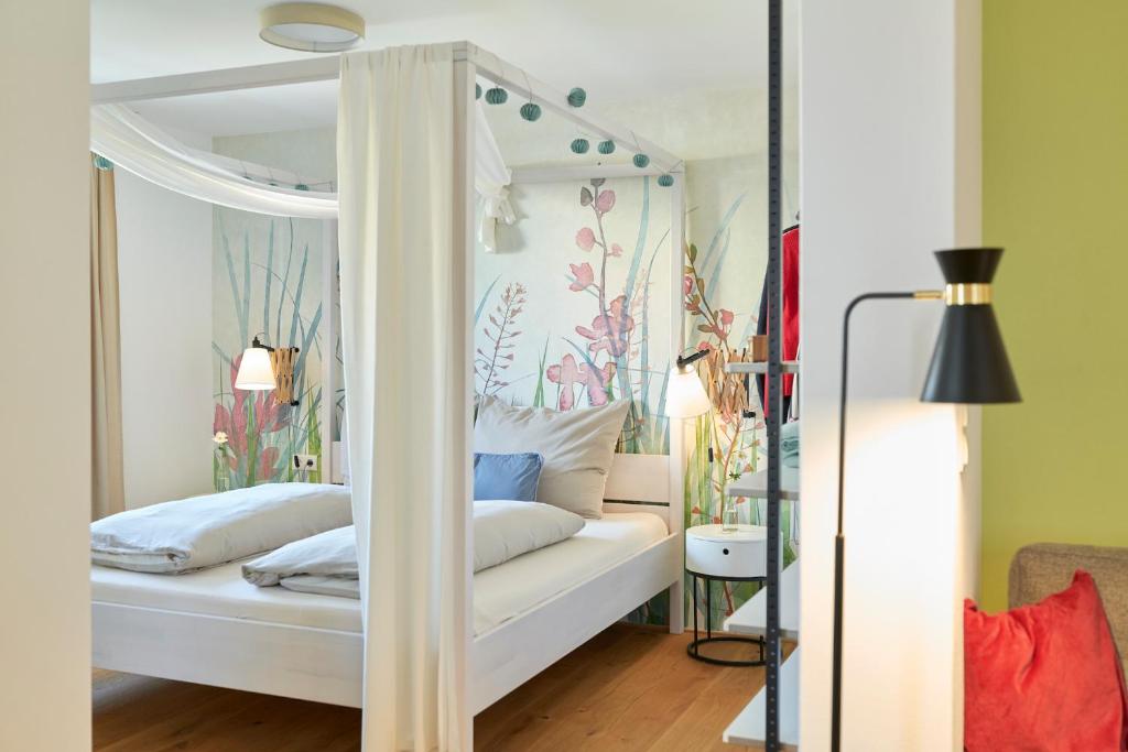 布雷根茨Rotes Haus Bregenz Garten Wohnung的卧室配有白色华盖床和鲜花