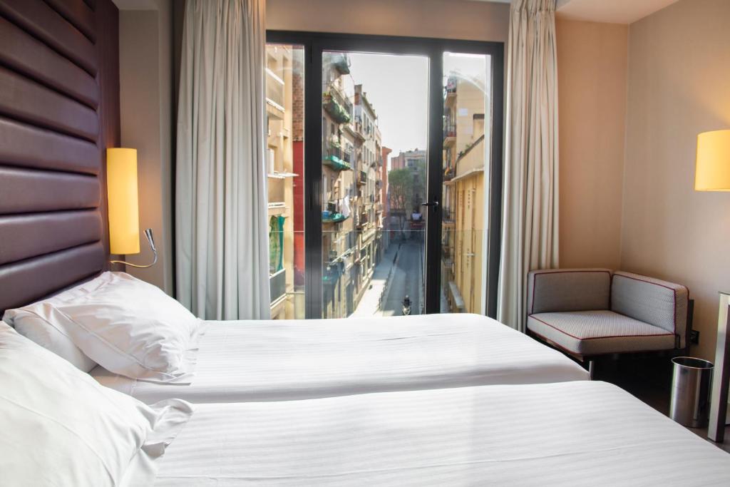 巴塞罗那巴塞罗那佩斯塔纳竞技场酒店的一间设有大床和窗户的酒店客房