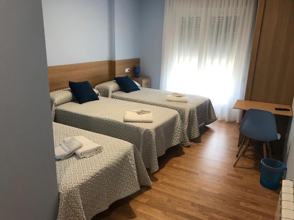 帕拉斯德丽Pensión Santirso的一间房间,配有三张床和餐巾