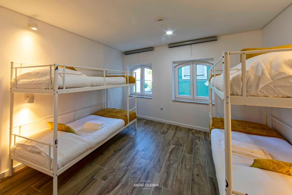 拉梅戈Host'olaria的客房设有三张双层床,铺有木地板。