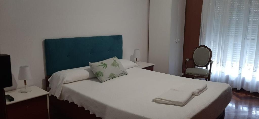 桑托尼亚ALOJAMIENTO CASA LEÓN的一间卧室配有一张白色大床和蓝色床头板
