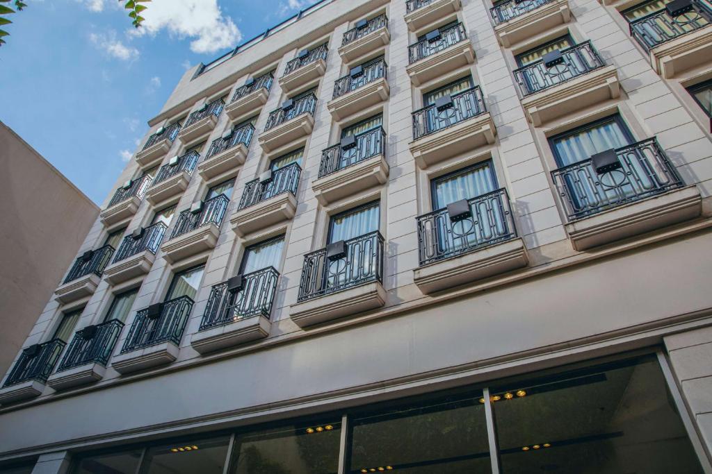 布宜诺斯艾利斯Esplendor by Wyndham Buenos Aires Tango的一座高大的建筑,旁边设有阳台