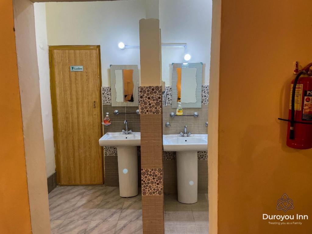 吉尔吉特Duroyou Inn的浴室设有2个水槽和2面镜子