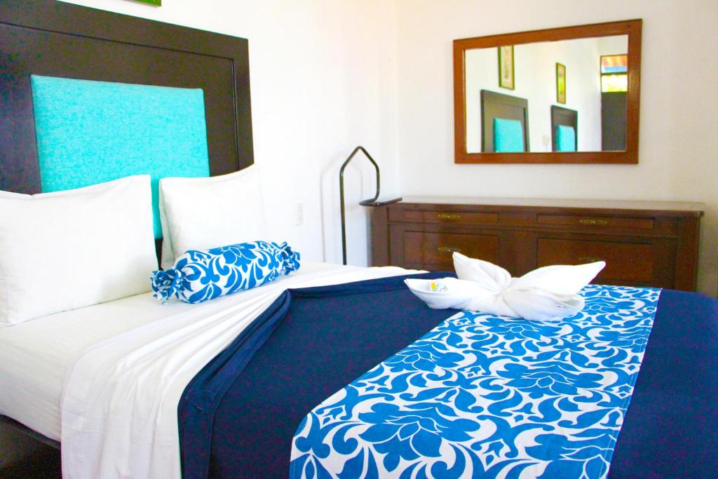 特克塞丁戈Hotel Ameyali Tequesquitengo的卧室配有一张带镜子的蓝色和白色床