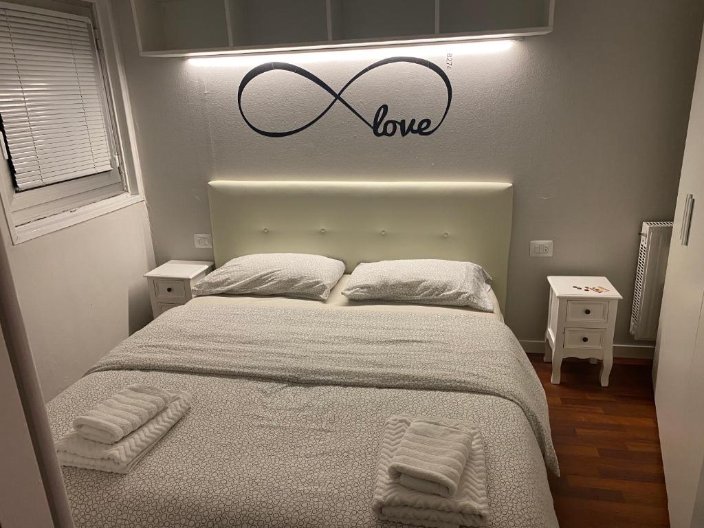 韦尔米廖Luna Bianca Apartment的一间卧室,上方有一张带爱情标志的床