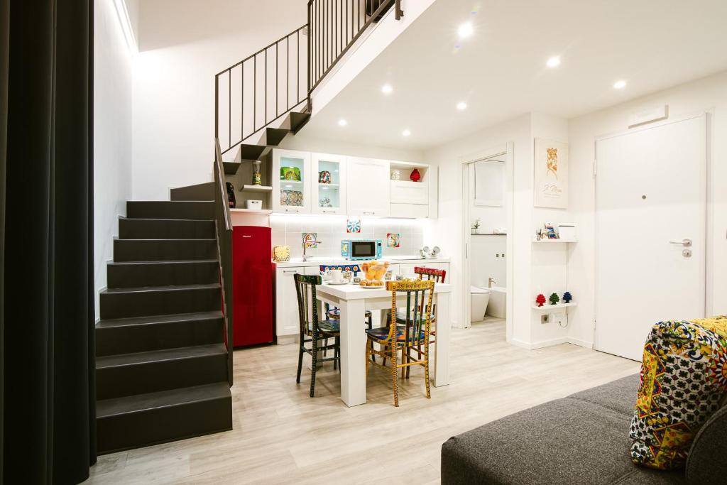 卡塔尼亚Il Moro Boutique Apartment的一间带楼梯的客厅和一间带桌子的厨房