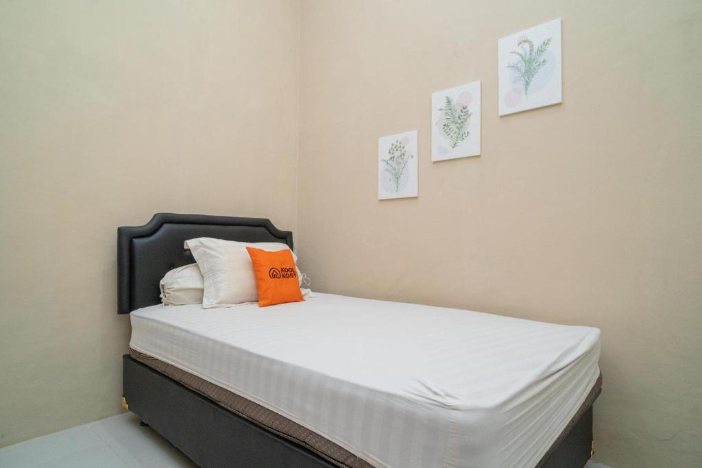 Sungai LutusKoolkost Syariah near Jalan Ahmad Yani Banjarmasin的一间卧室配有一张带橙色枕头的床