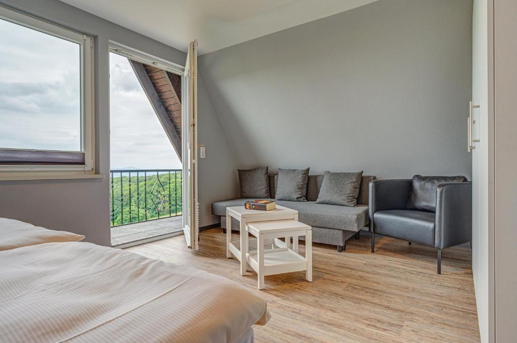 布罗特罗德Ferienhaus Hohe Klinge的一间卧室配有一张床、一张沙发和一个窗口