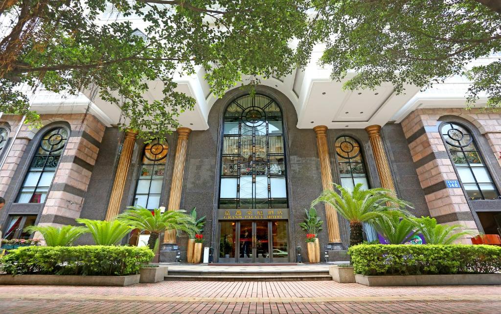 广州广州嘉逸豪庭酒店的一座建筑前面有大窗户和植物