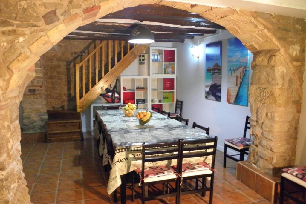 LazagurríaCasa rural, 15 personas, 7 habitaciones,gran salón的一间设有桌子和石墙的用餐室