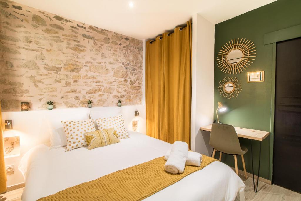 尼姆Appartement Cosy Nîmes-Centre的一间卧室配有一张床和一张桌子及椅子