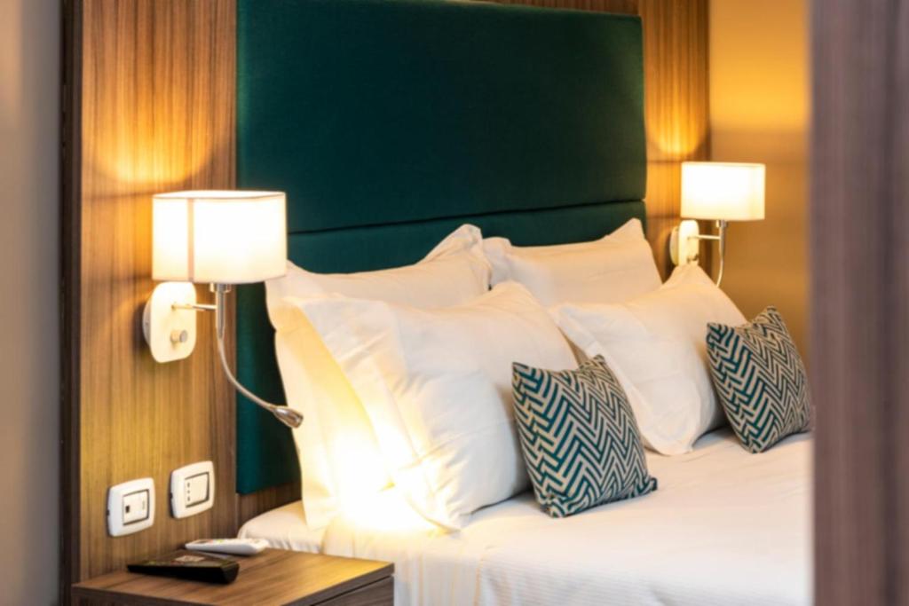 罗马Aurelia Antica Suites & Apartments的一间卧室配有一张带白色枕头的床和绿色床头板。