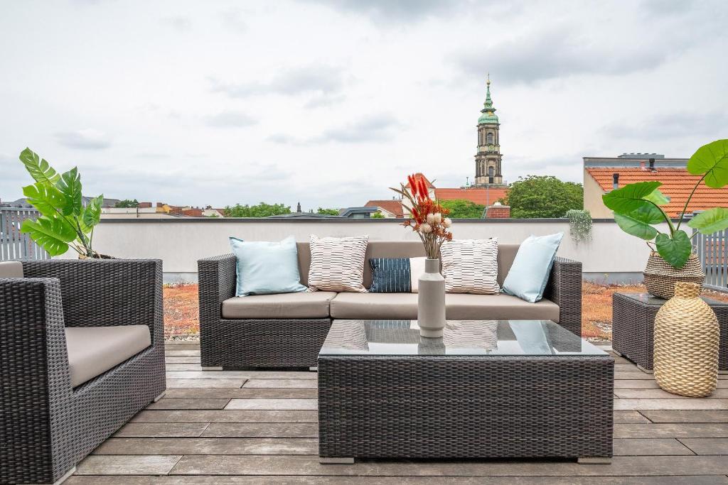 柏林numa I Nook Rooms & Apartments的一个带柳条家具和一张桌子的庭院