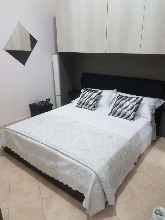 蒂沃利Casetta di Diego的一间卧室配有一张白色的床和黑色床头板