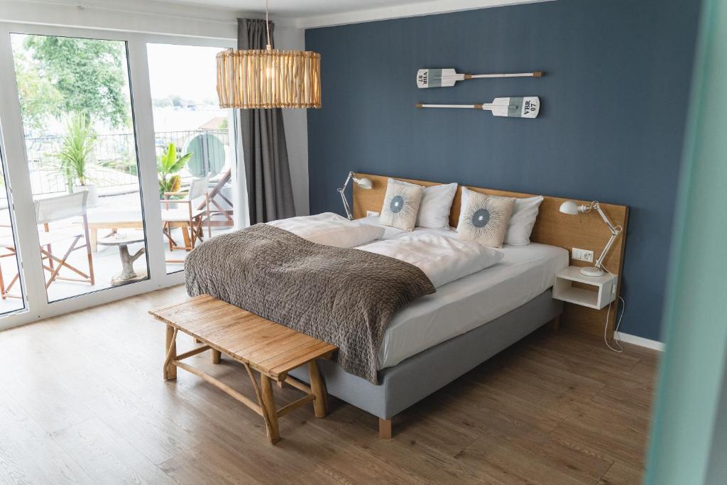 塞布鲁克QC Hotel Quartier Chiemsee的一间卧室配有一张蓝色墙壁的床