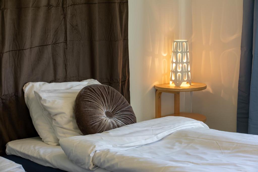 SkinnskattebergSystemairhallen Bed&Breakfast的一张带枕头的床和一张桌子上的台灯