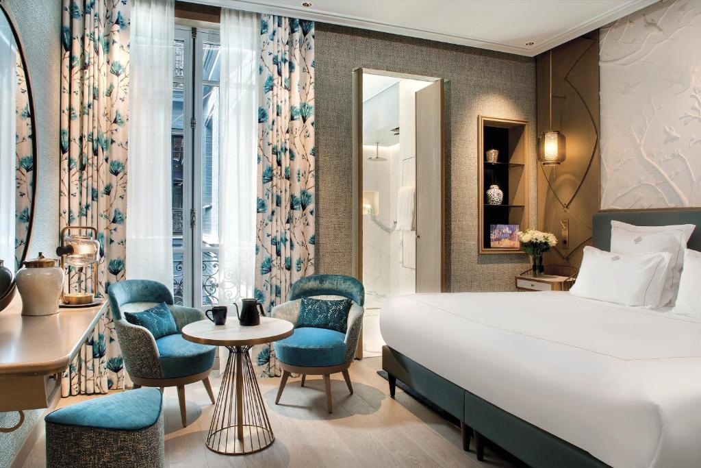 巴黎La Demeure Montaigne的酒店客房,配有床和椅子
