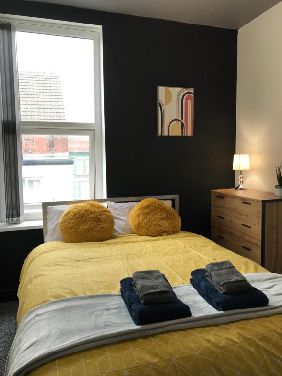 利物浦CLIFTON Apartments的一间卧室配有一张床,上面有两条毛巾