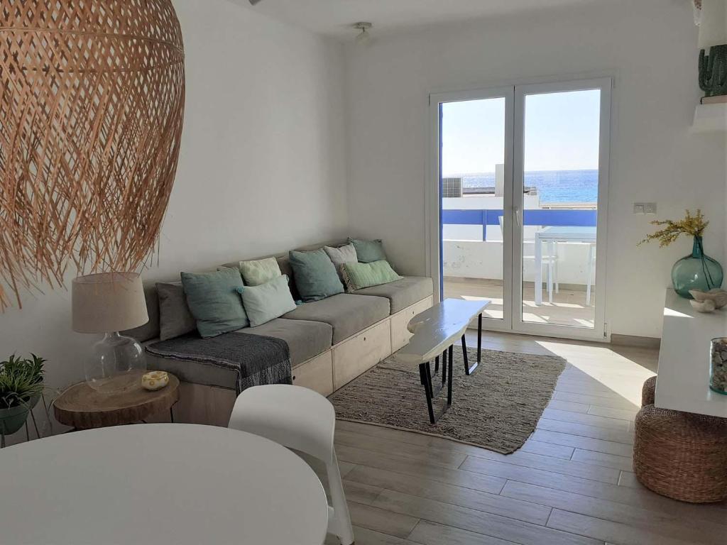 阿瓜阿马加Precioso Apartamento a 20 metros del mar的带沙发的客厅,享有海景