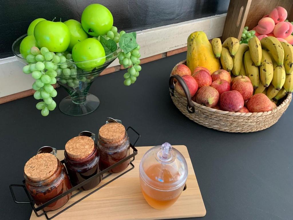 瓜鲁柳斯圣丹尼尔酒店的一张桌子,上面有一篮水果和一罐果酱