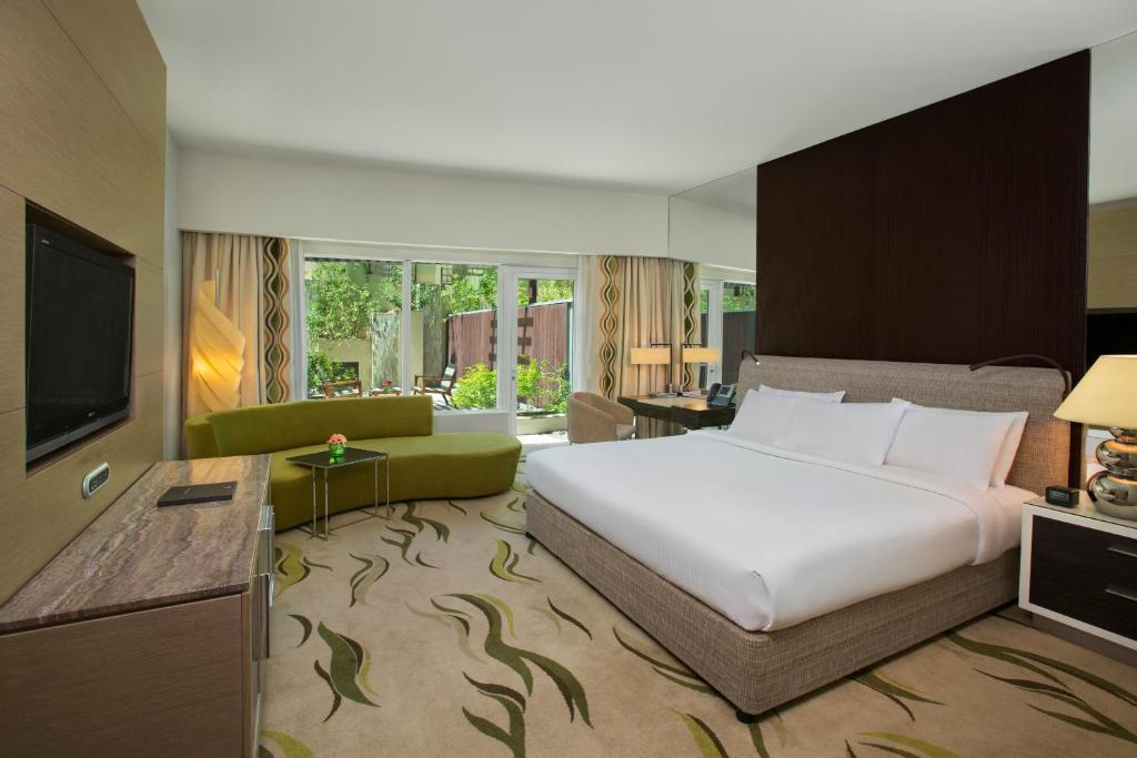 阿布扎比Millennium Al Rawdah Hotel的卧室配有一张白色大床和电视。