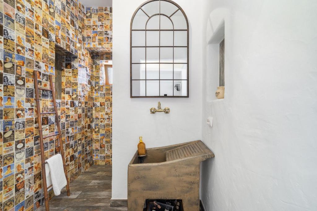 埃斯坦巴Casa Celeiro的一间带木制水槽和一堵照片墙的浴室