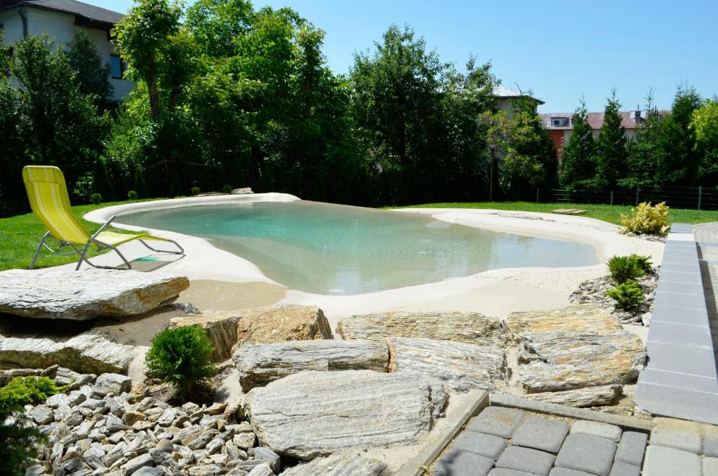 伊沃尼奇-兹德鲁伊威拉鲁比尼亚旅馆的水池,有黄色的椅子和岩石