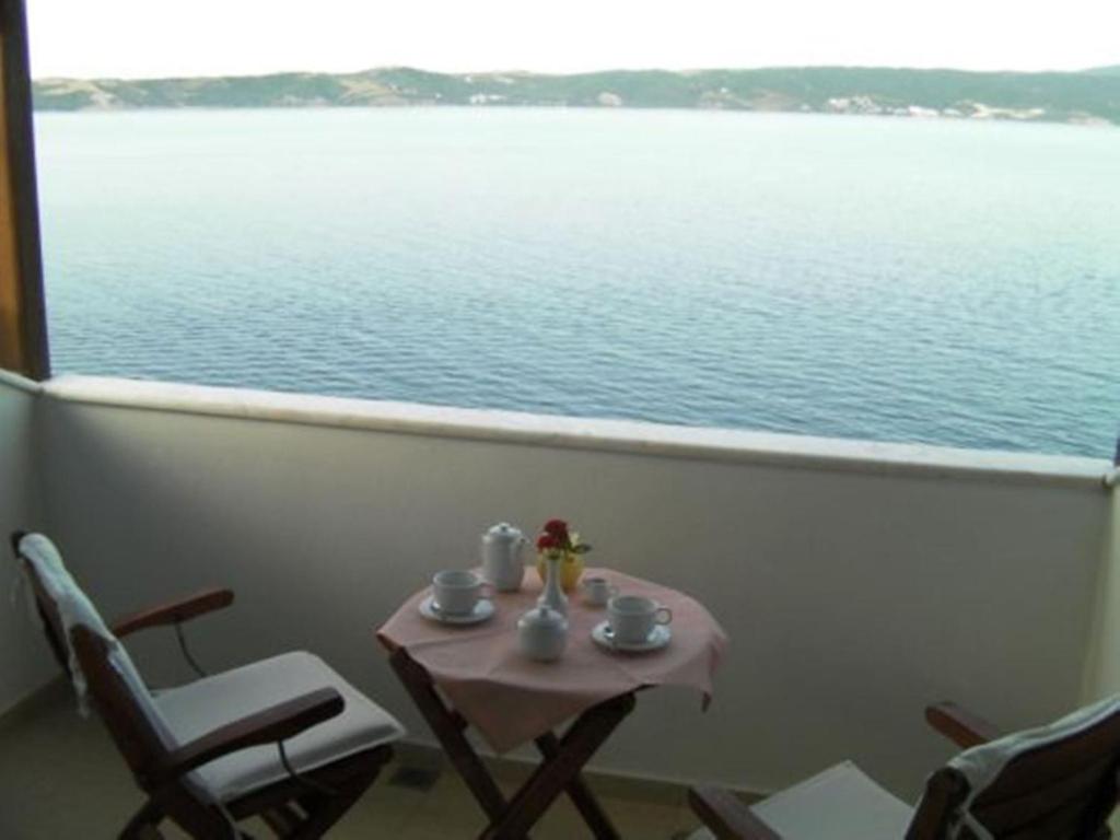 阿莫利亚尼岛阿莫利亚尼酒店的阳台配有桌椅,享有水景