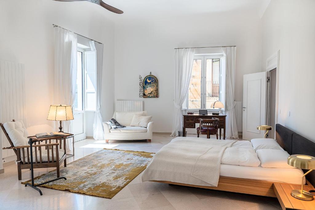 莱切Palazzo Charlie的一间白色的卧室,配有床和客厅