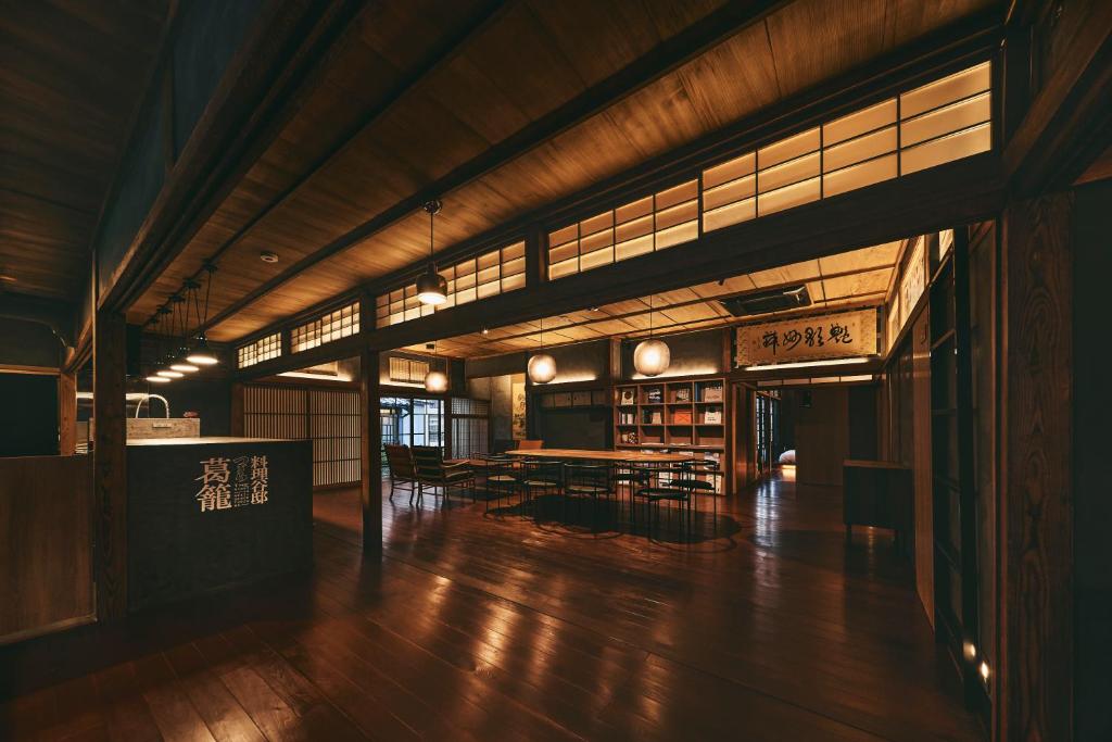 熊本Tudzura的大型客房,铺有木地板,设有桌子和窗户。