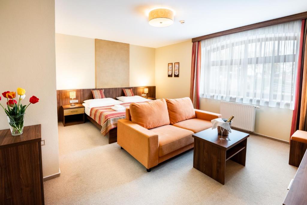 Žirovnice阿塔班酒店的酒店客房,配有床和沙发