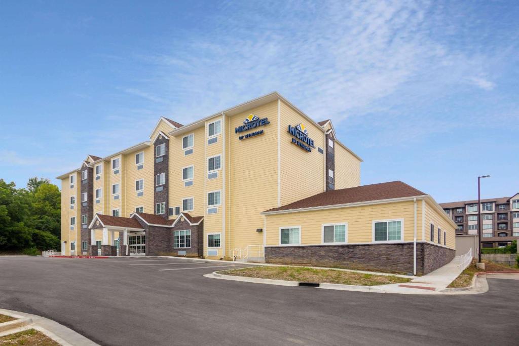 利伯蒂Microtel Inn & Suites by Wyndham Liberty NE Kansas City Area的大型酒店前面设有停车场