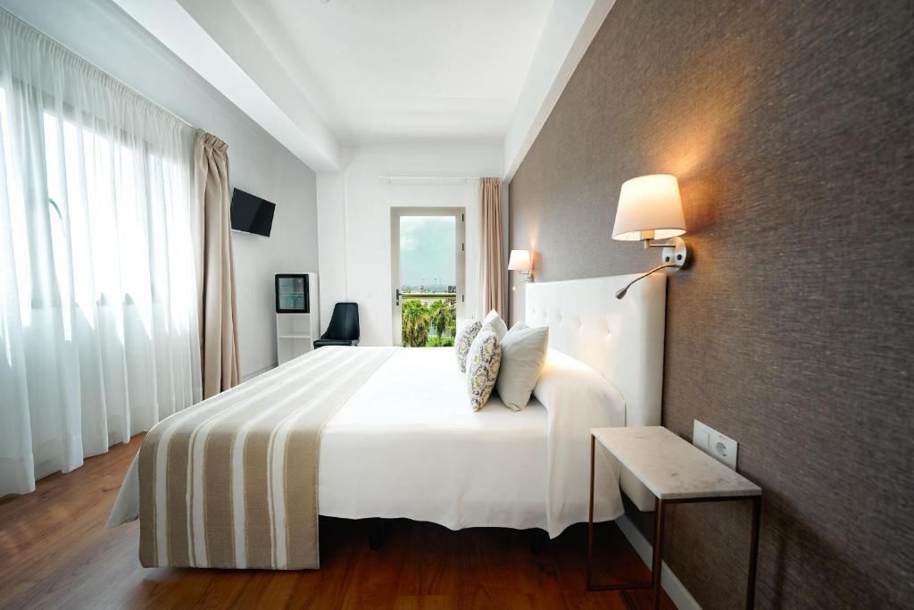 大加那利岛拉斯帕尔马斯Hotel Matilde by Grupo Matilde的卧室设有一张白色大床和一扇窗户。