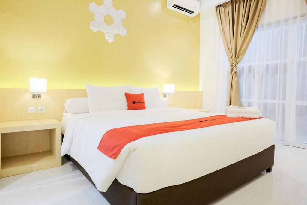 KedatonRedDoorz Plus Syariah near Museum Lampung的一间卧室设有一张大床和一个窗户。