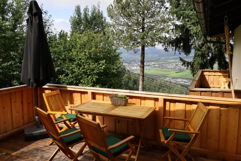 GrossvolderbergAppartement 'Oachkatzl'的木制甲板上的木桌和椅子