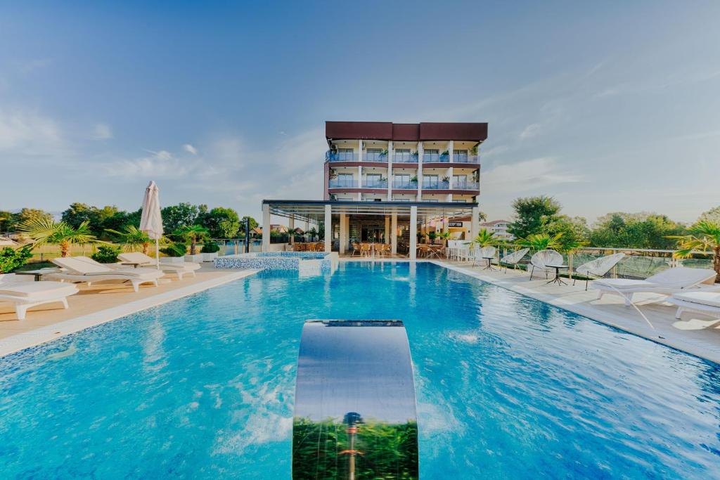 乌尔齐尼狮子酒店的酒店游泳池的背景是一座建筑