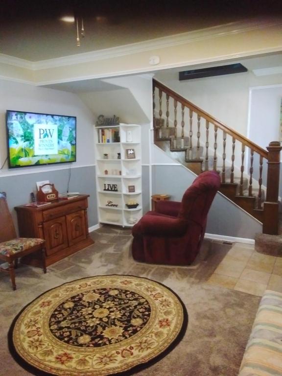 塔尔萨3-Br 2-Bath Family-Friendly Home -10 Min to Tulsa的客厅配有电视、椅子和地毯。