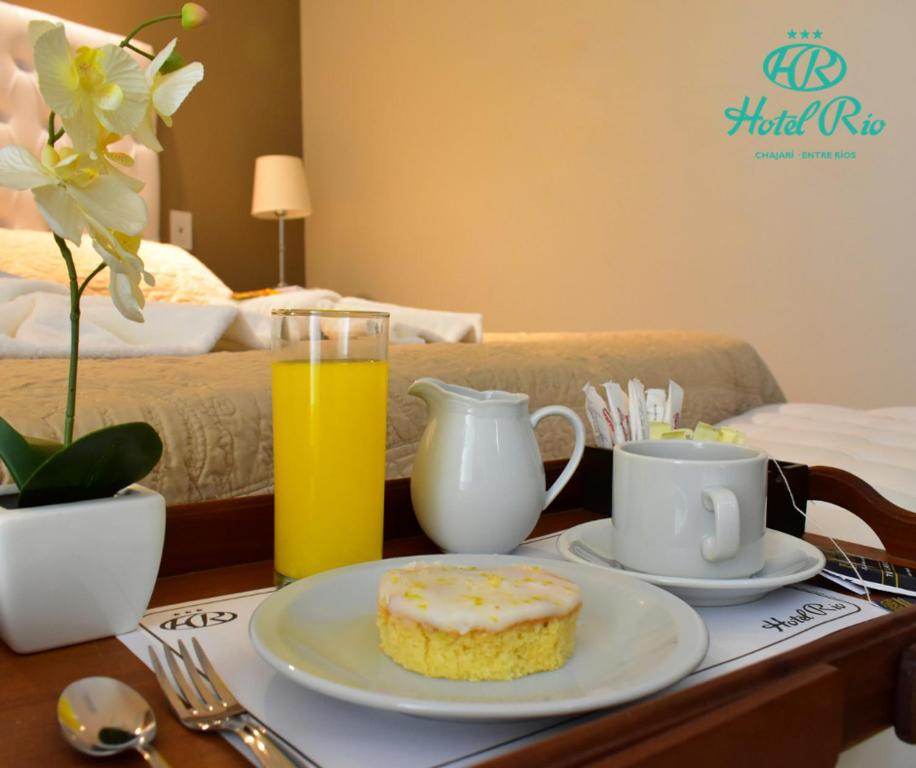 查哈里Hotel Río的一张桌子,上面有盘子,上面有甜甜圈和一杯橙汁
