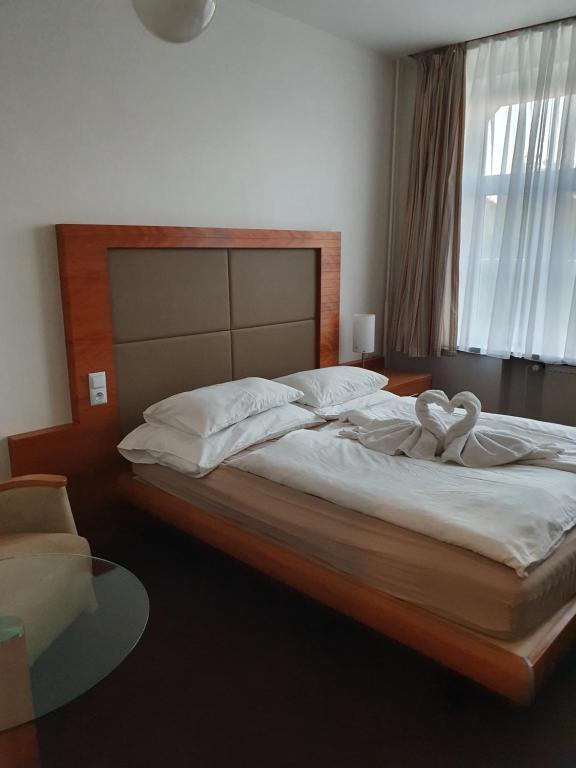布拉格亚瑞比克酒店的一间卧室配有一张带两个天鹅的床