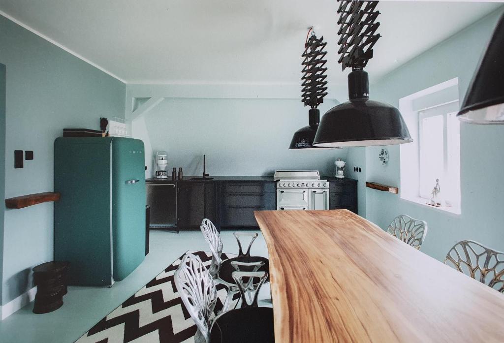 韦斯特兰Haus Noge Sylt - Offizierhaus Design Appartments strandnah的厨房配有木桌和绿色冰箱。