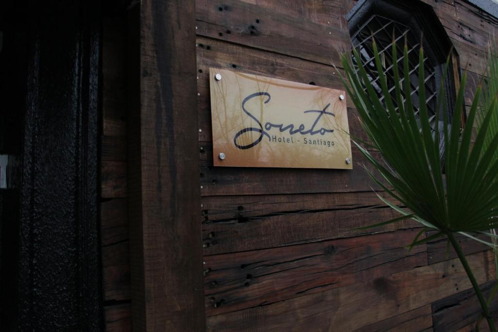 圣地亚哥Hotel Sonetto的木墙边的标志