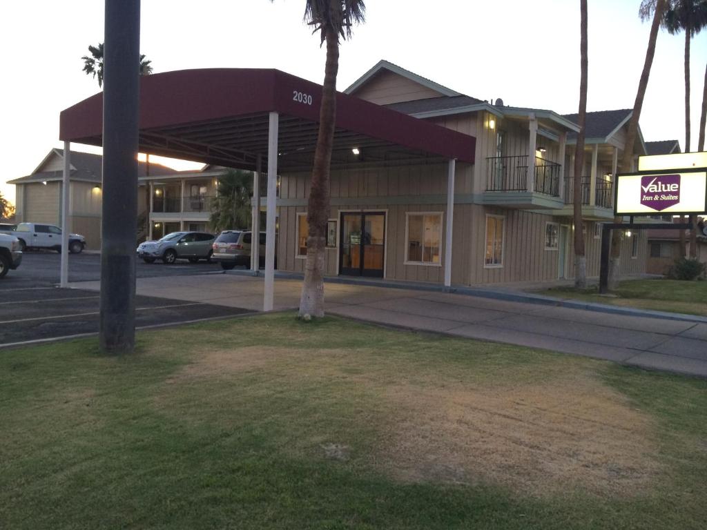 埃尔森特罗Value Inn & Suites的停车场前有棕榈树的建筑