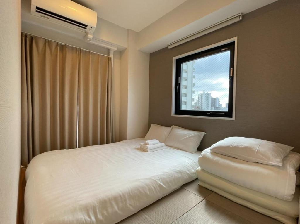东京The Light Inn - Vacation STAY 94696的卧室配有白色的床和窗户。
