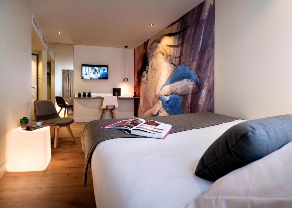 巴黎麦克斯酒店的一间卧室设有一张床和一间客厅。