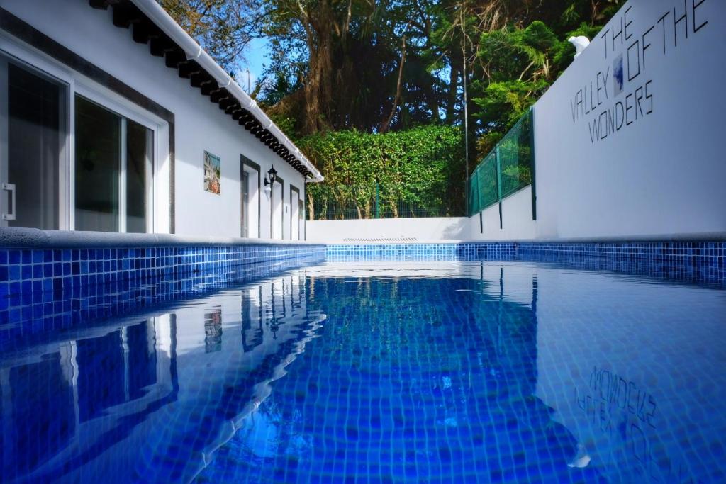 富尔纳斯Vale dos Encantos的白色建筑旁边的蓝色游泳池