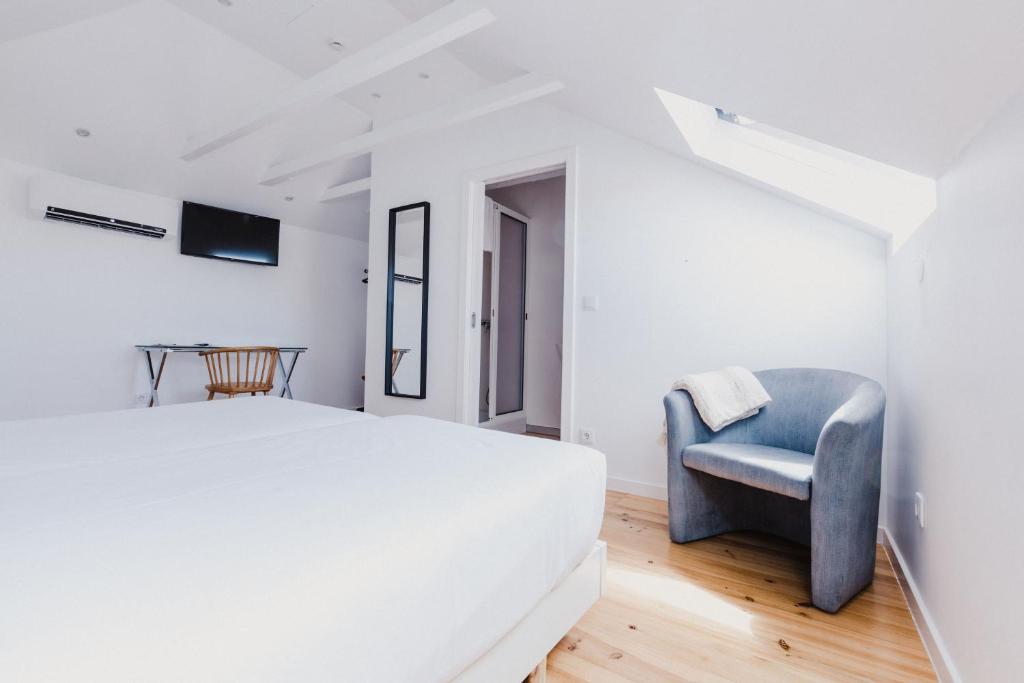 丰沙尔Jaca Hostel Funchal的一间卧室配有一张床和一张蓝色椅子